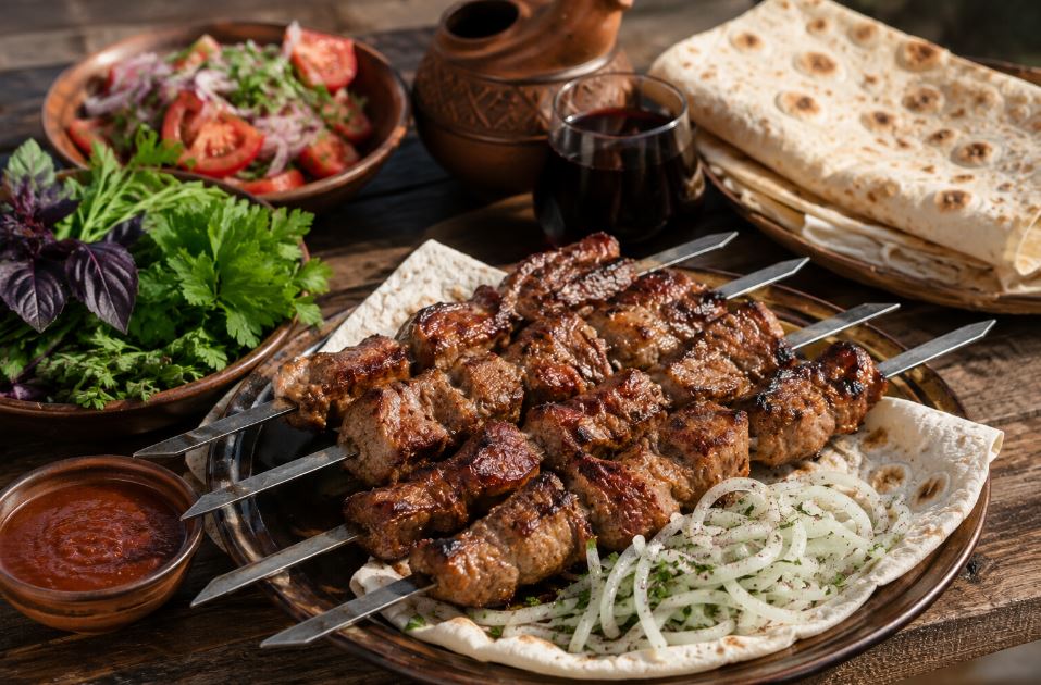 Armenian khorovats served with lavash bread, fresh herbs and traditional vegetables