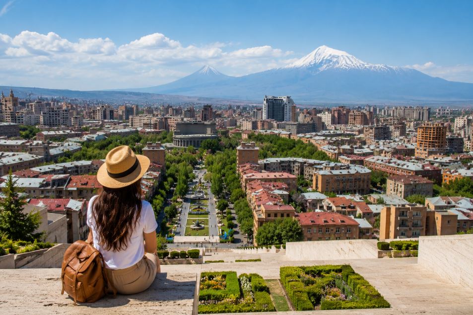 Traveler sitting at Cascade and looking at panoramic view of Yerevan with Mount Ararat