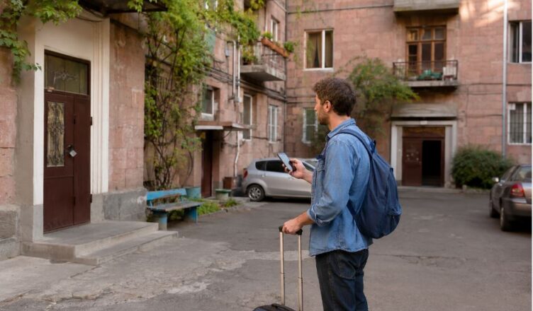 Traveler using a smartphone to find an apartment entrance in a Yerevan courtyard